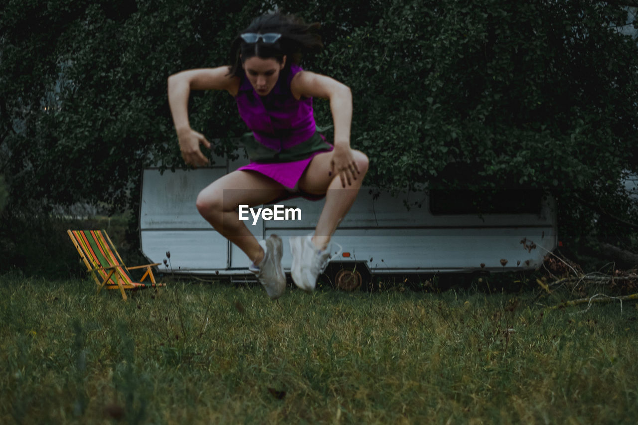 Woman jumping over field