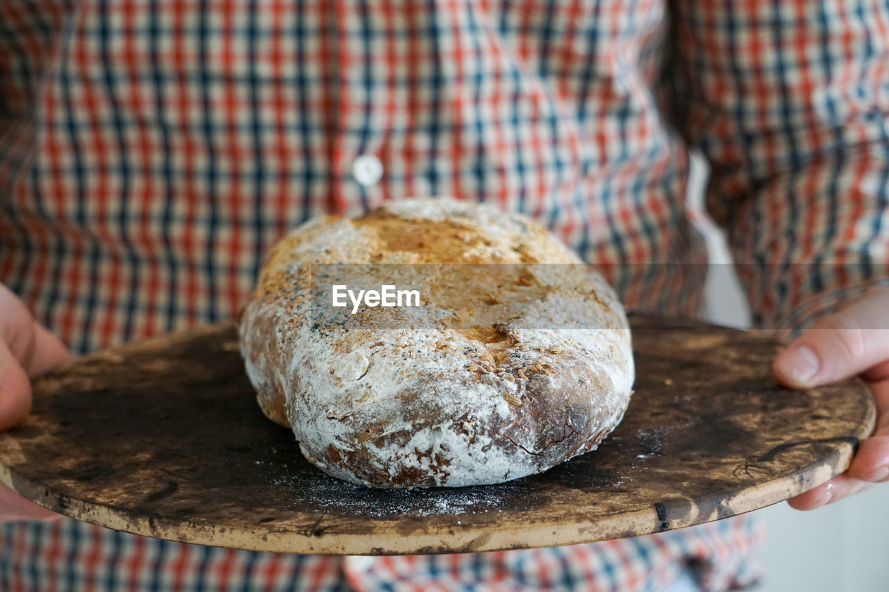 Close-up of hand holding homemade sourdough bread