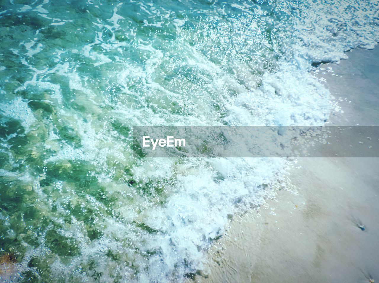 HIGH ANGLE VIEW OF WAVE SPLASHING ON SEA