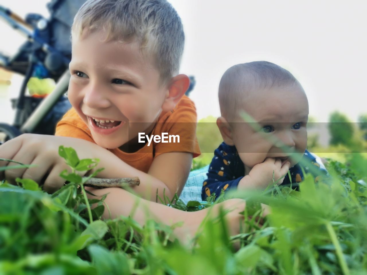 Close-up of cute boy and baby playing in yard