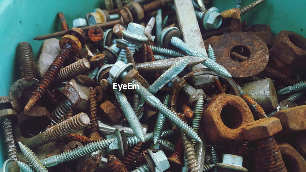 HIGH ANGLE VIEW OF RUSTY METAL IN CONTAINER AT WORKSHOP