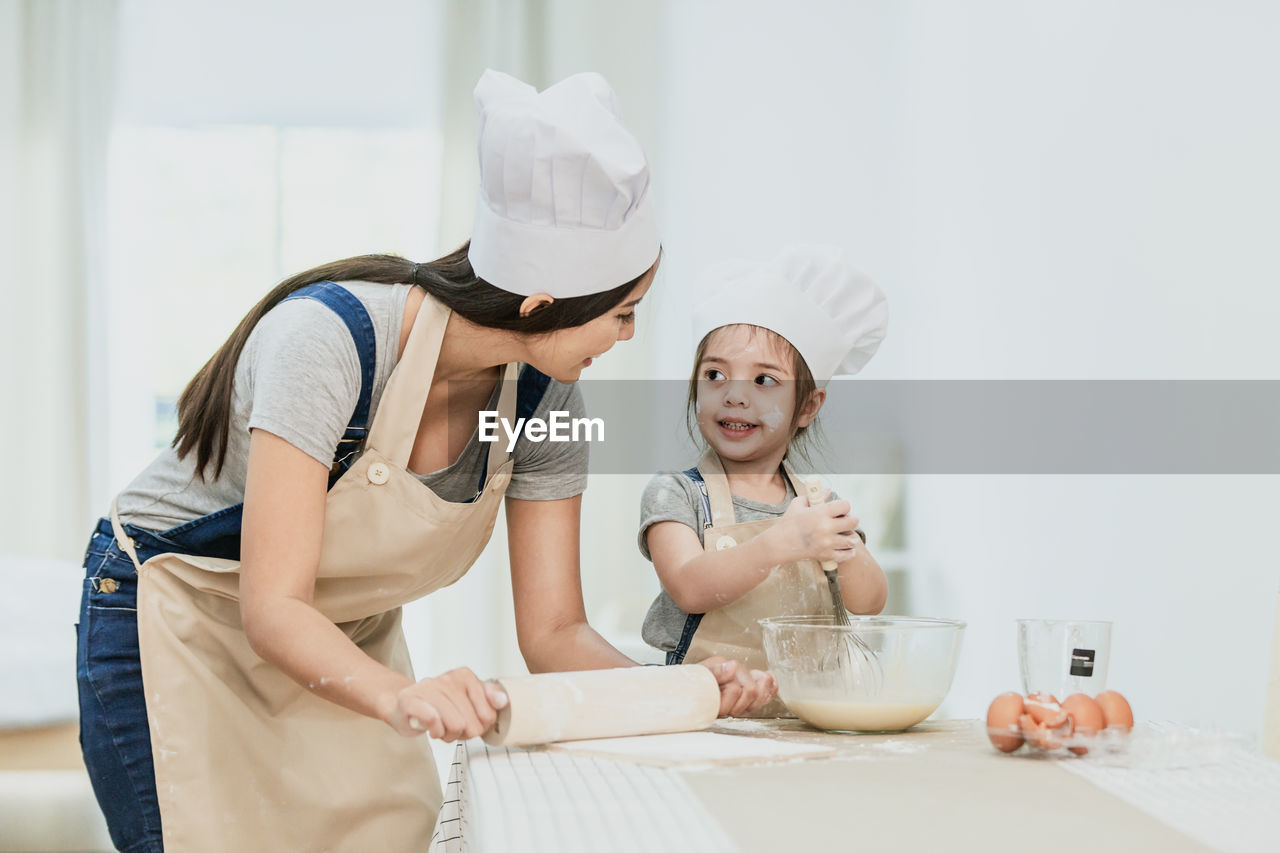 WOMAN HOLDING FOOD IN KITCHEN