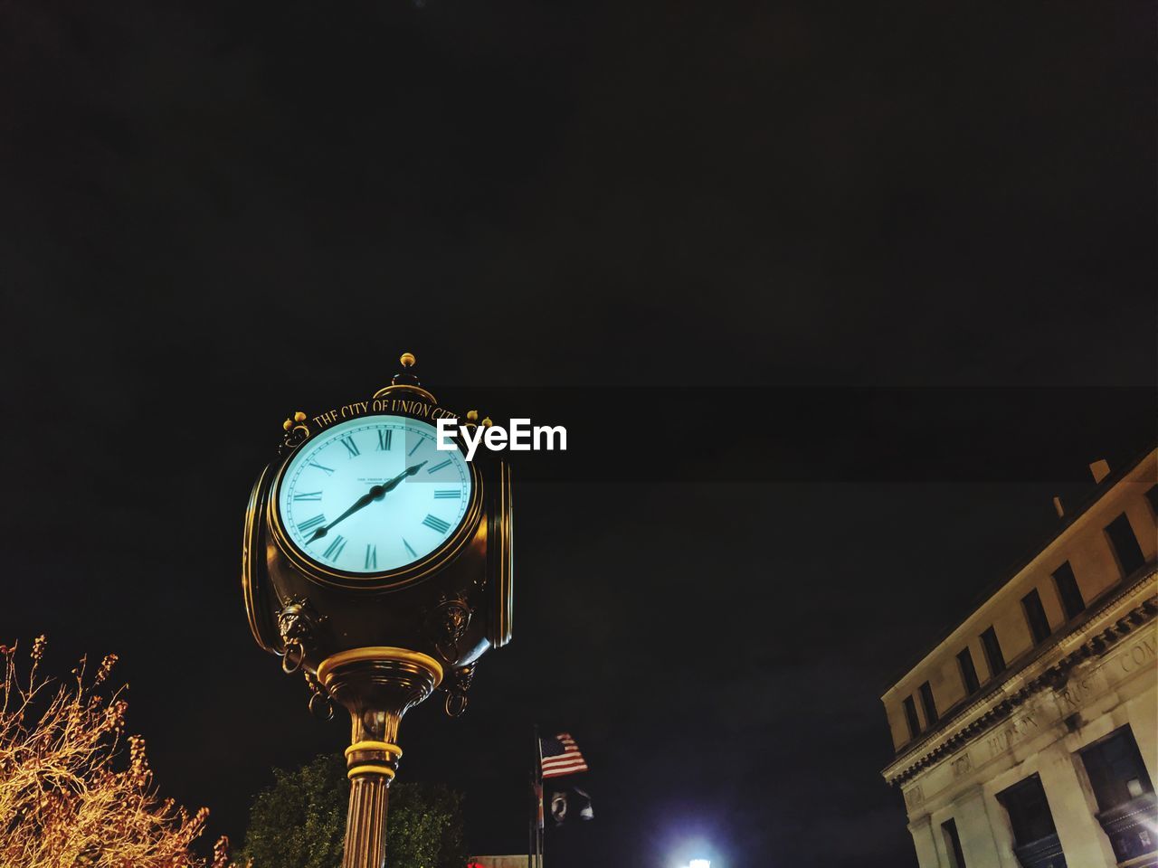 Low angle view of illuminated clock tower at night