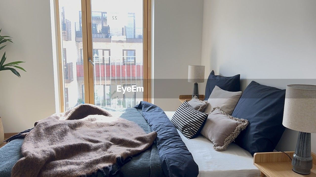 furniture, domestic room, indoors, home interior, window, room, living room, lifestyles, home, relaxation, domestic life, bedroom, sofa, pillow, comfortable, bed, cozy, day, interior design, home showcase interior, stuffed, no people, apartment, wealth, luxury, architecture, table, chair, house, cushion