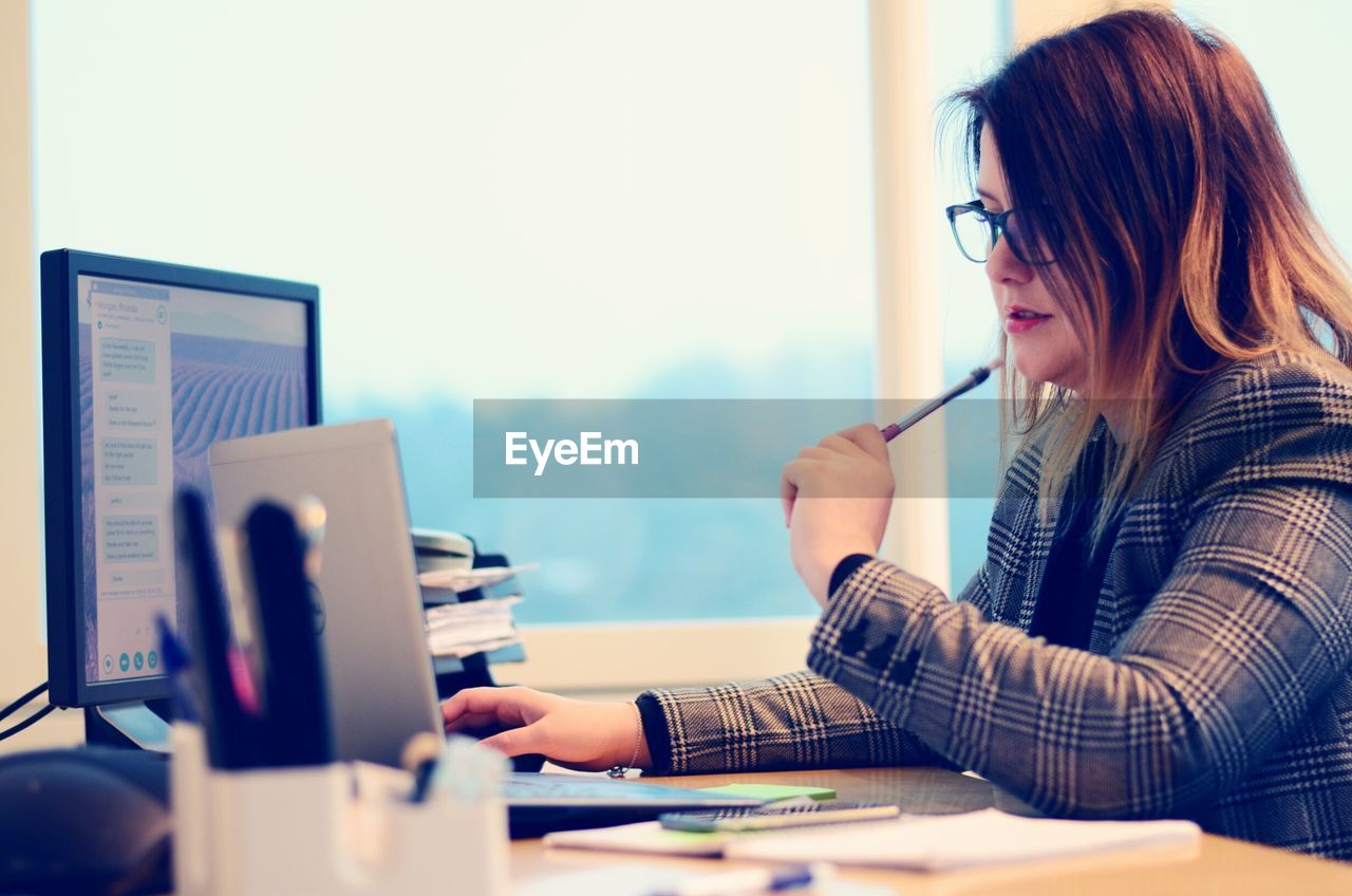 Young businesswoman working at computer desk in office