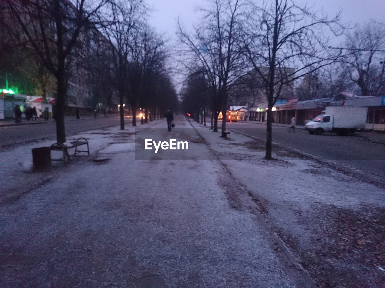 PEOPLE WALKING ON SNOW COVERED ROAD