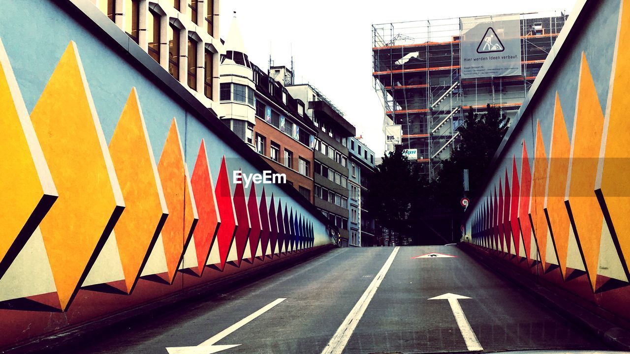 ROAD AMIDST BUILDINGS AGAINST SKY