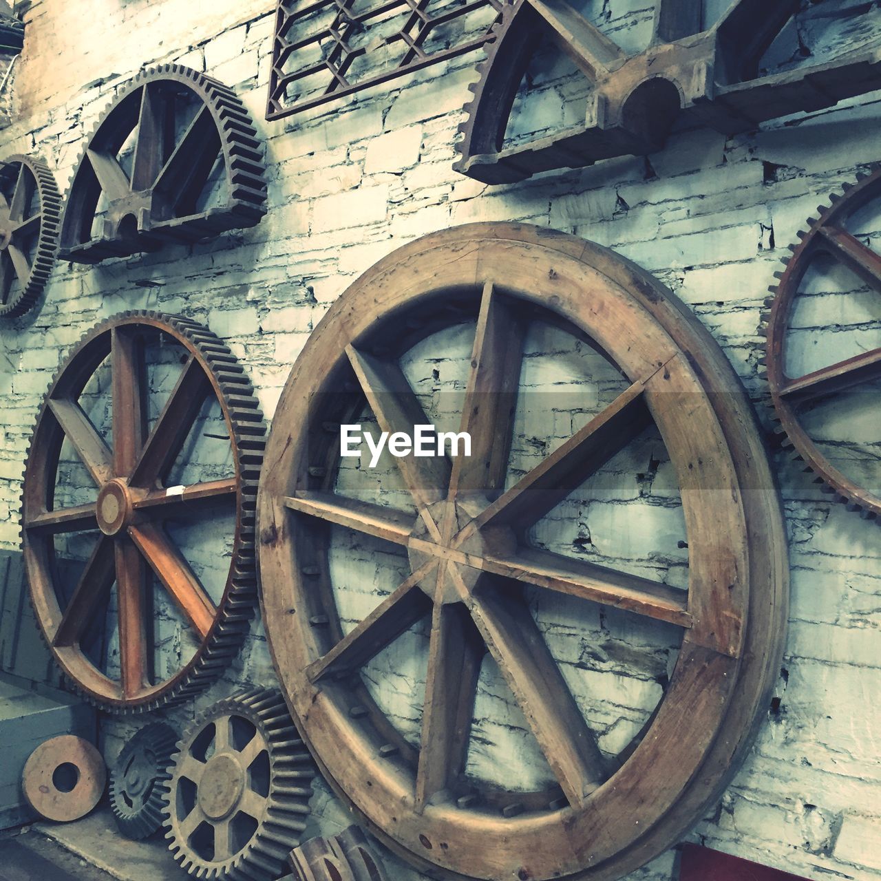 Old wheels mounted on brick wall in museum