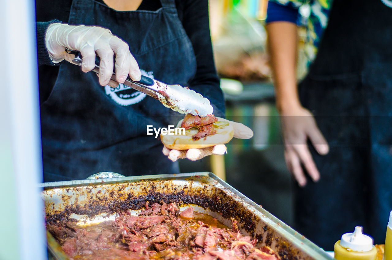 Midsection of man preparing food at market stall