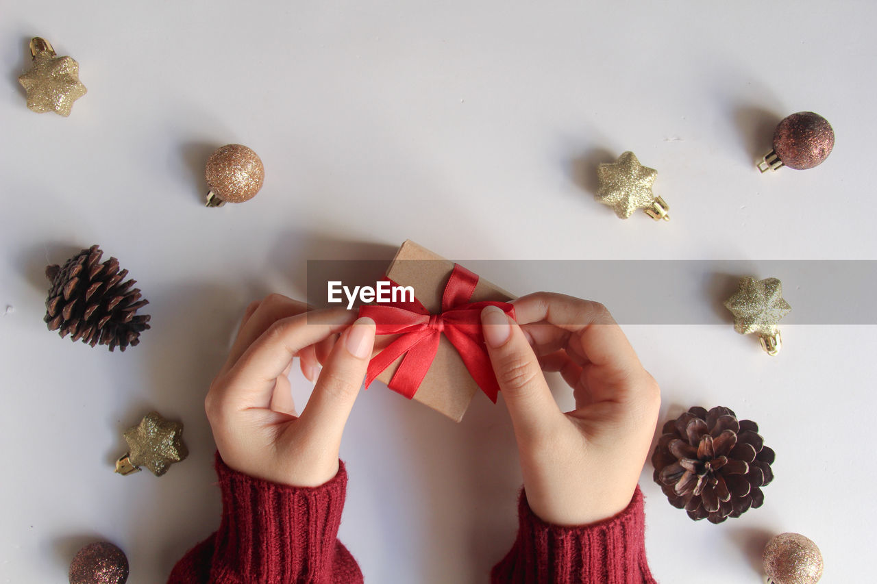 cropped hands of woman holding christmas decorations