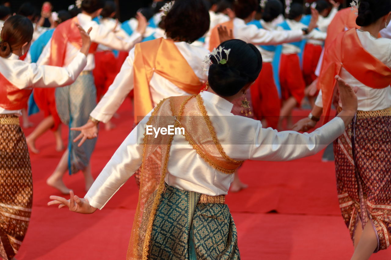 Rear view of women wearing traditional clothing while dancing outdoors