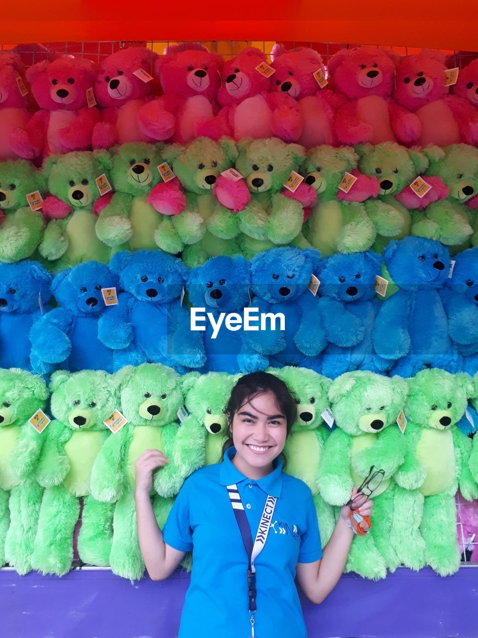 Portrait of smiling girl standing against teddy bears at market