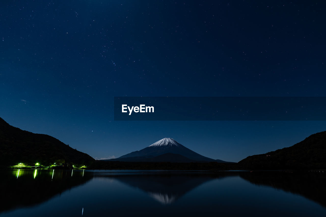 Scenic view of lake against sky at night