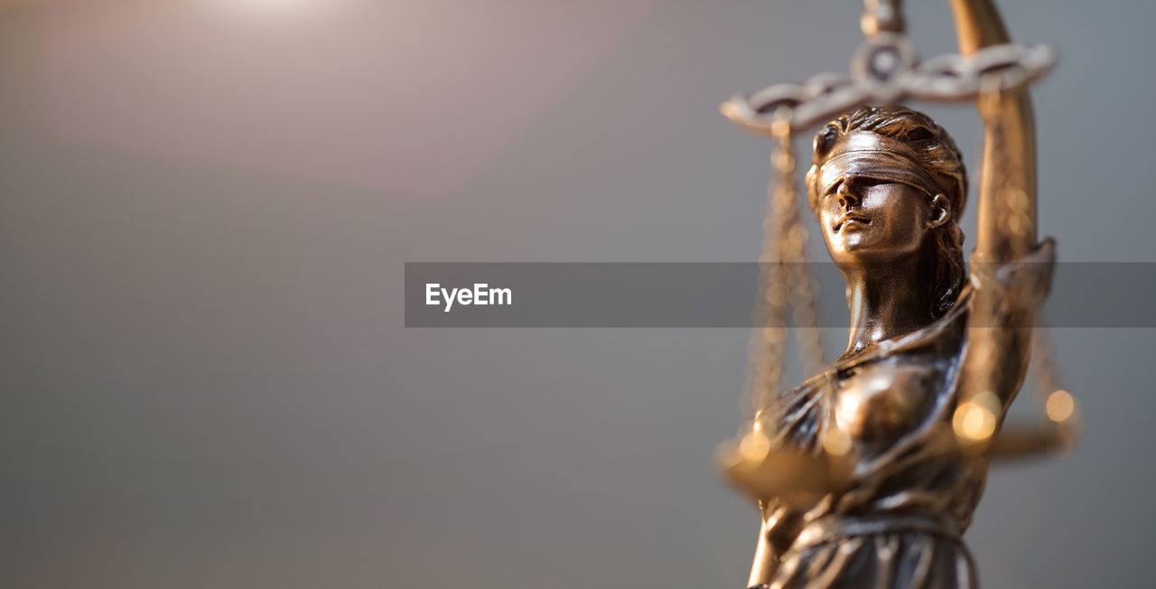 Close-up of lady justice statue against black background