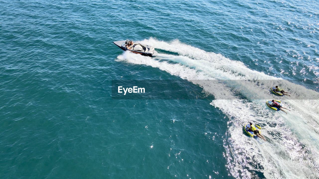 HIGH ANGLE VIEW OF PEOPLE AT SEA