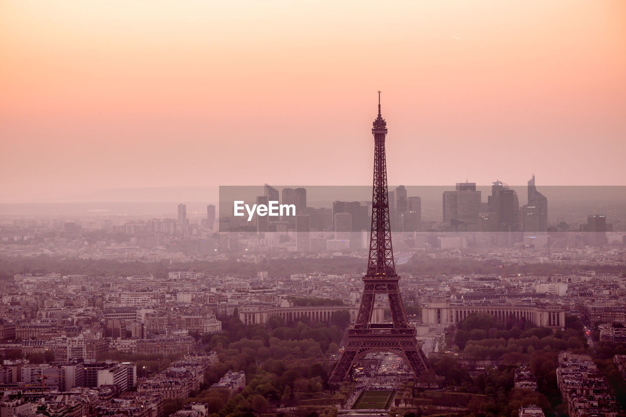 Aerial view of buildings in city at sunset