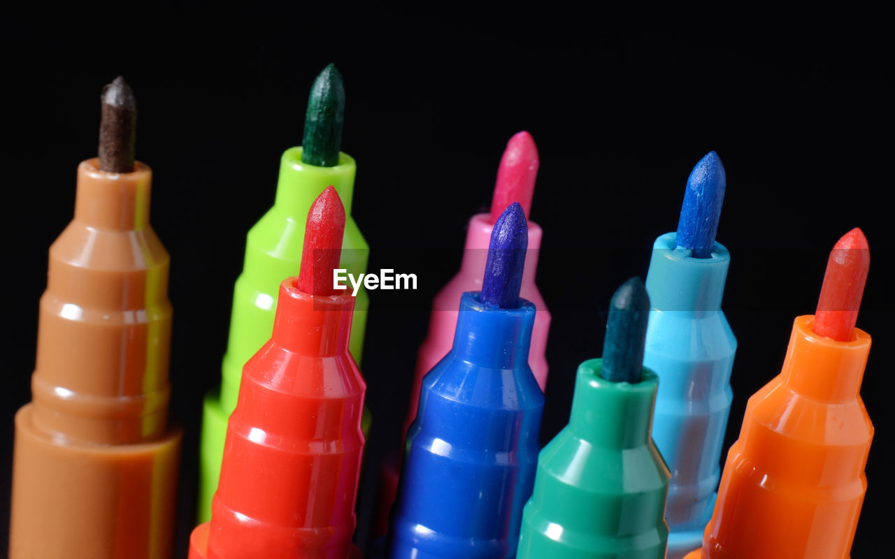 CLOSE-UP OF MULTI COLORED BOTTLES IN CONTAINER