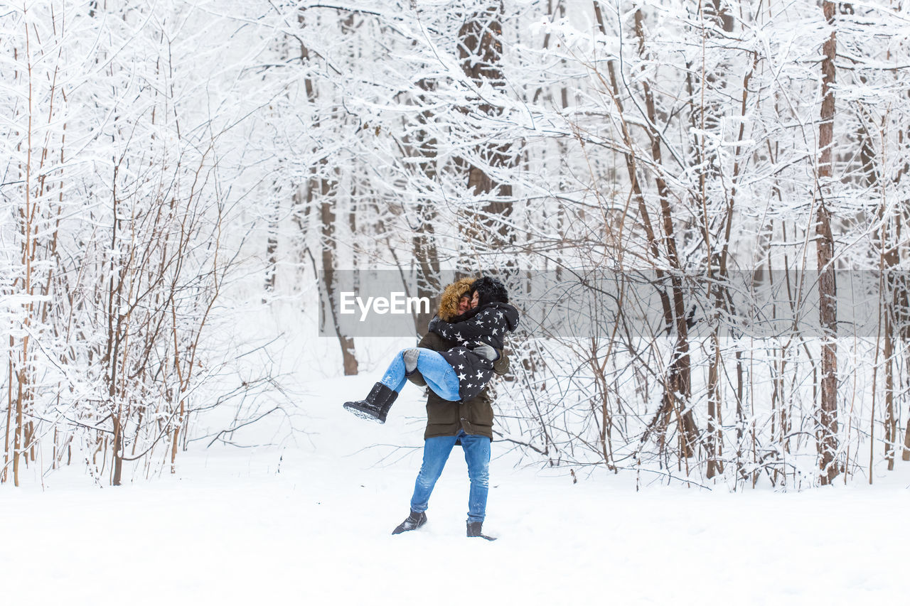FULL LENGTH OF WOMAN STANDING IN SNOW