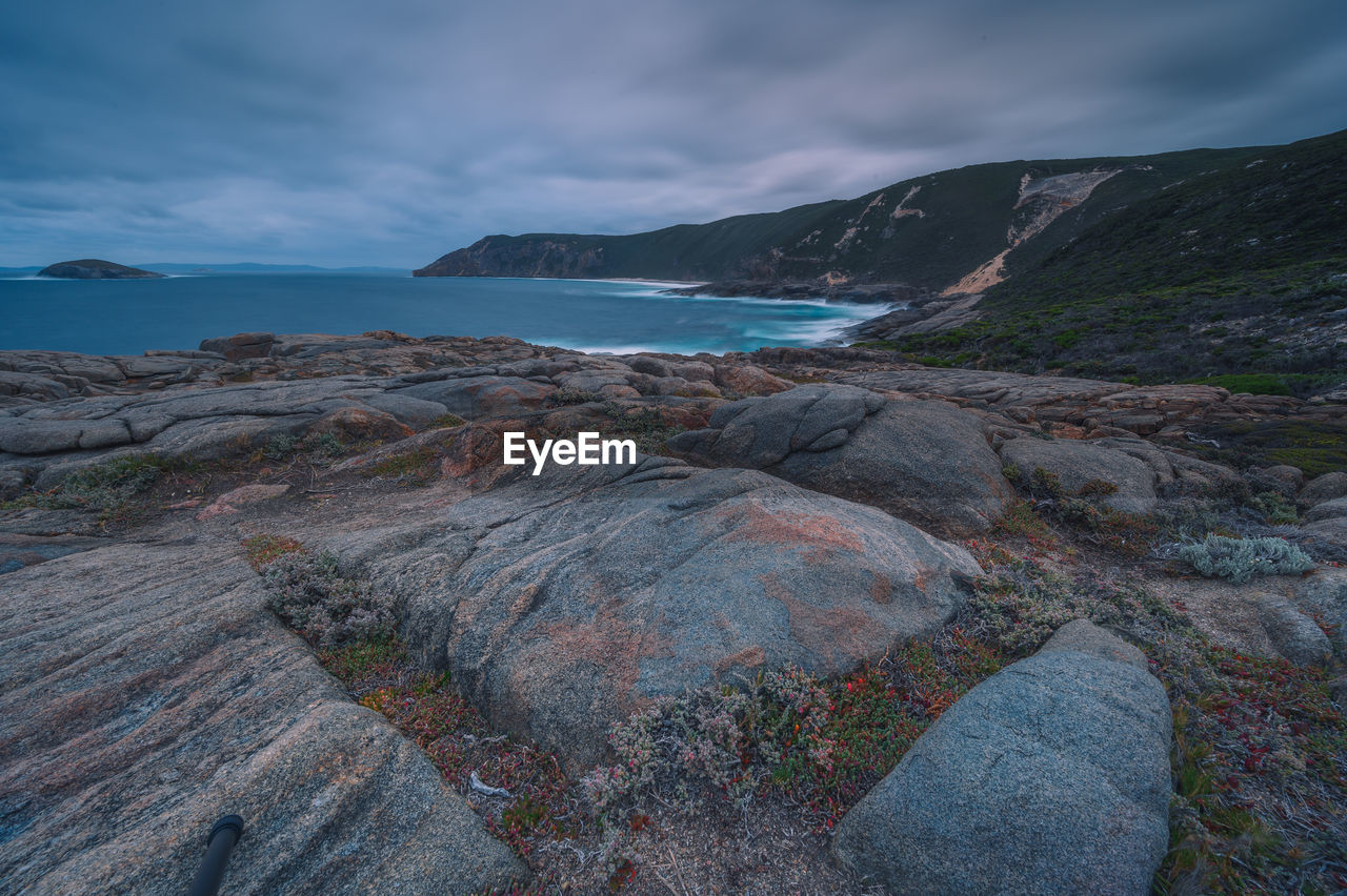 SCENIC VIEW OF SEA BY MOUNTAINS AGAINST SKY