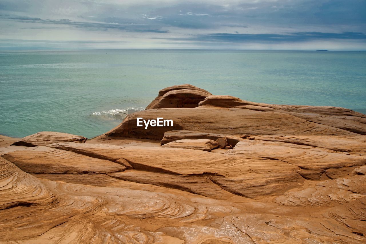 Rock formations in sea against sky