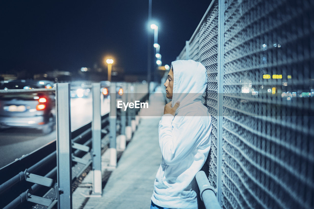 low angle view of man standing on street at night