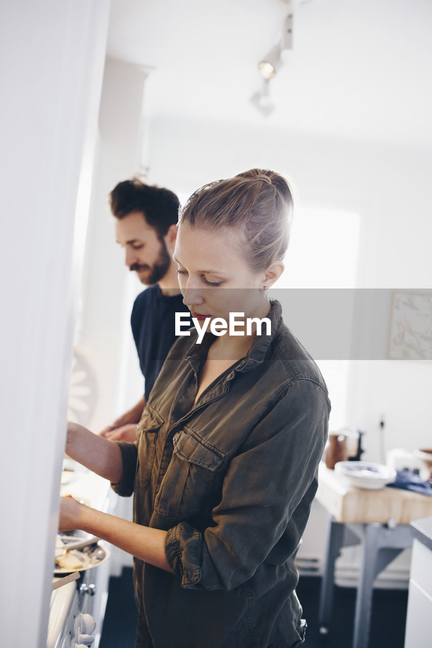 Tilt shot of couple working in kitchen at home