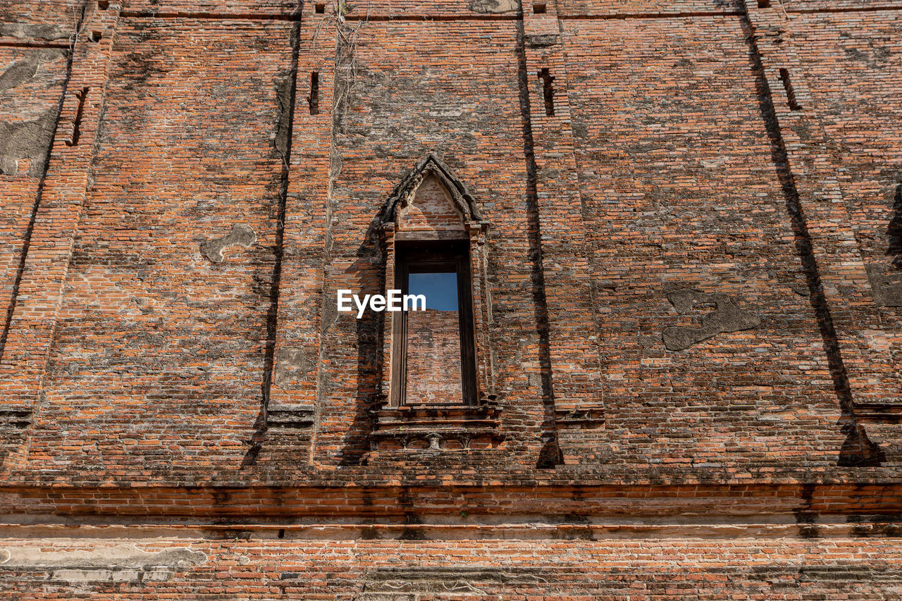 LOW ANGLE VIEW OF OLD WINDOW ON BUILDING