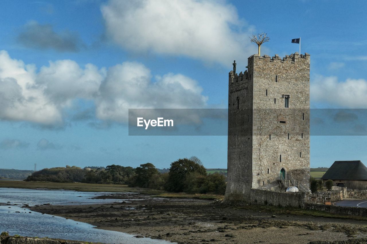 architecture, tower, sky, built structure, cloud, building exterior, sea, water, building, coast, nature, history, the past, travel destinations, land, no people, travel, beach, day, outdoors, blue, tourism, landscape, environment, castle