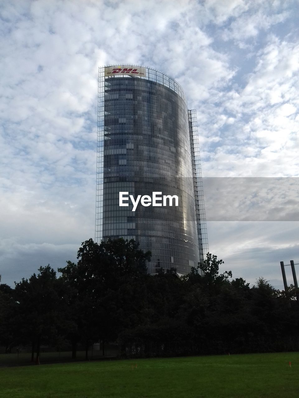 LOW ANGLE VIEW OF BUILDING AGAINST CLOUDS