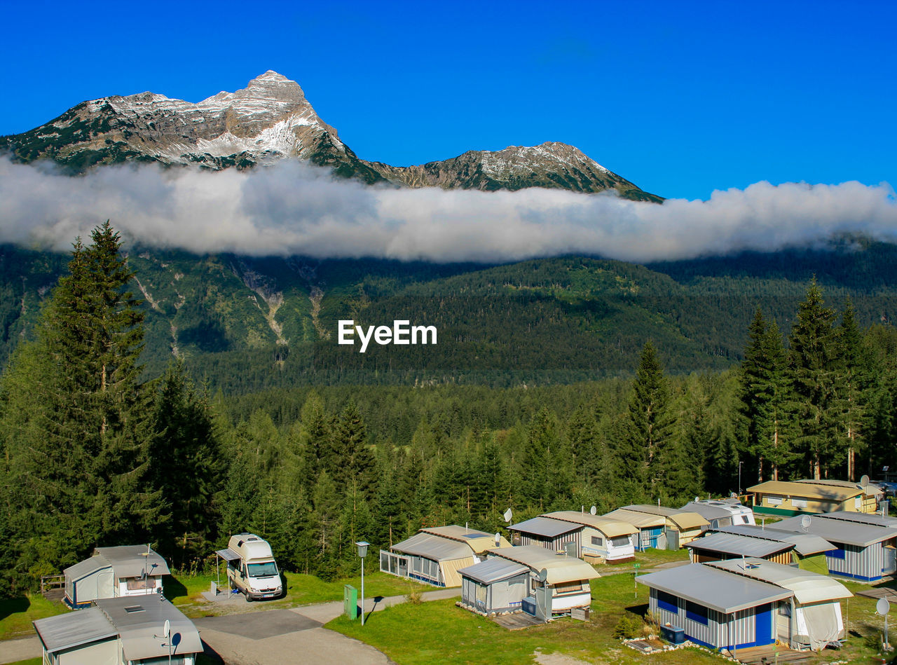 PANORAMIC VIEW OF BUILDINGS AND TREES AGAINST SKY