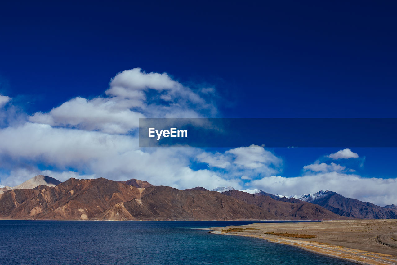 Scenic view of mountains against blue sky