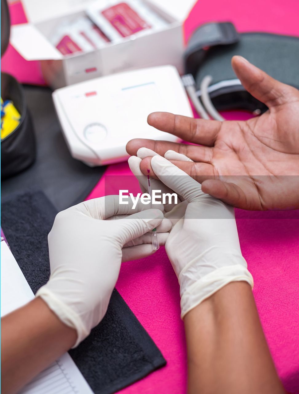 Cropped image of doctor doing blood sugar test of patient at hospital