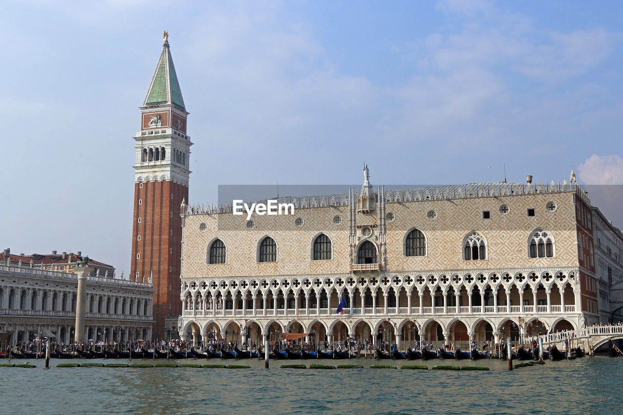 The bell tower of san marco and the palazzo ducale seen from the grand canal during a boat trip.