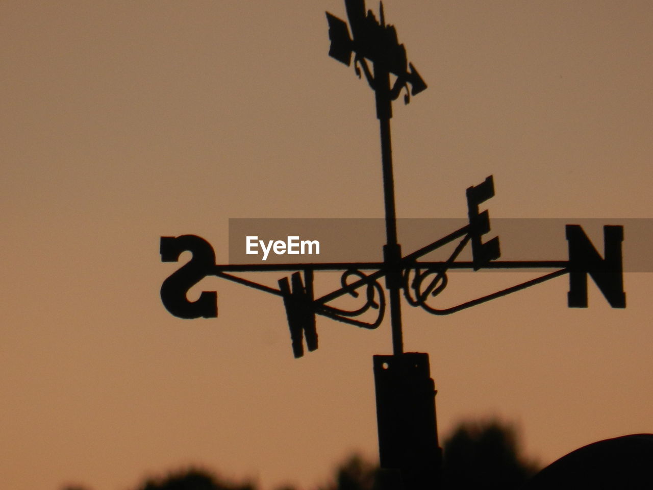 Low angle view of weather vane against sky