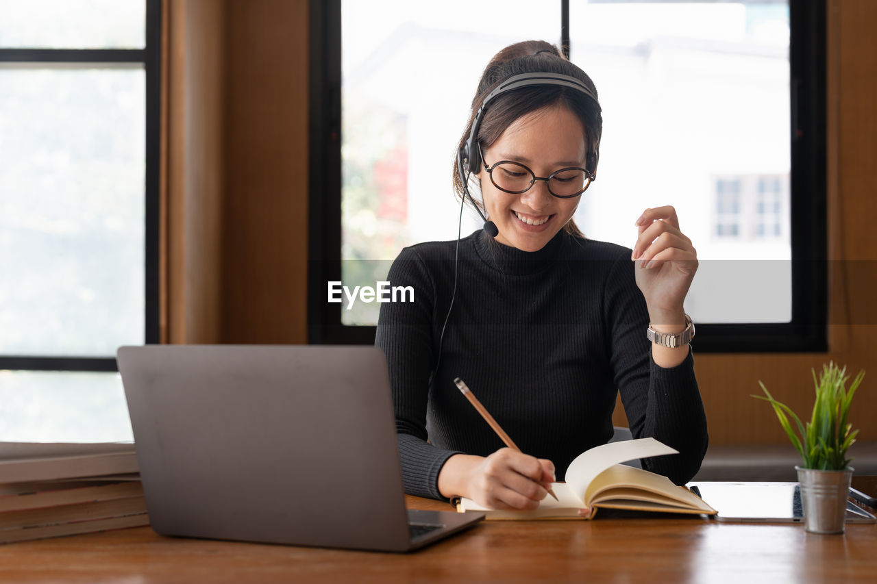 businesswoman using laptop while sitting on table