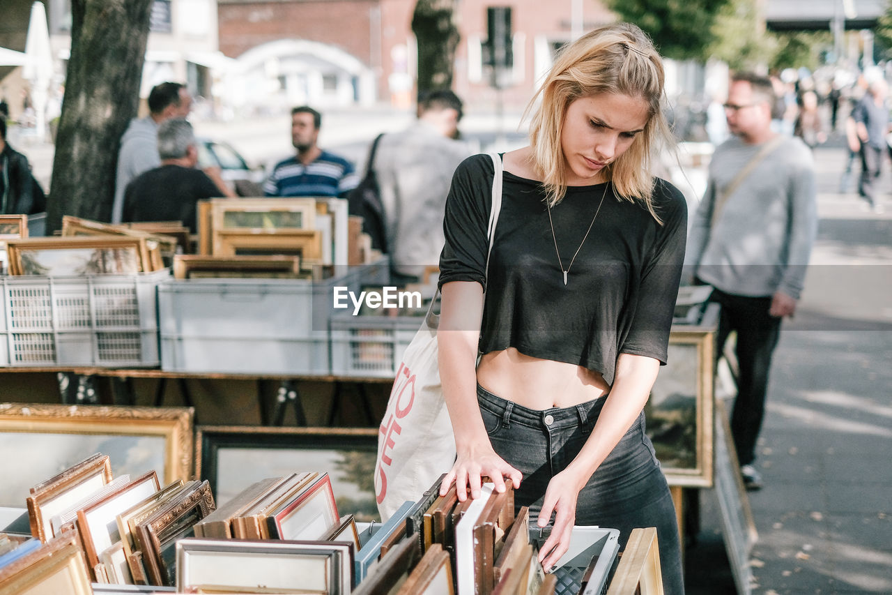 Young man buying frame at market in city