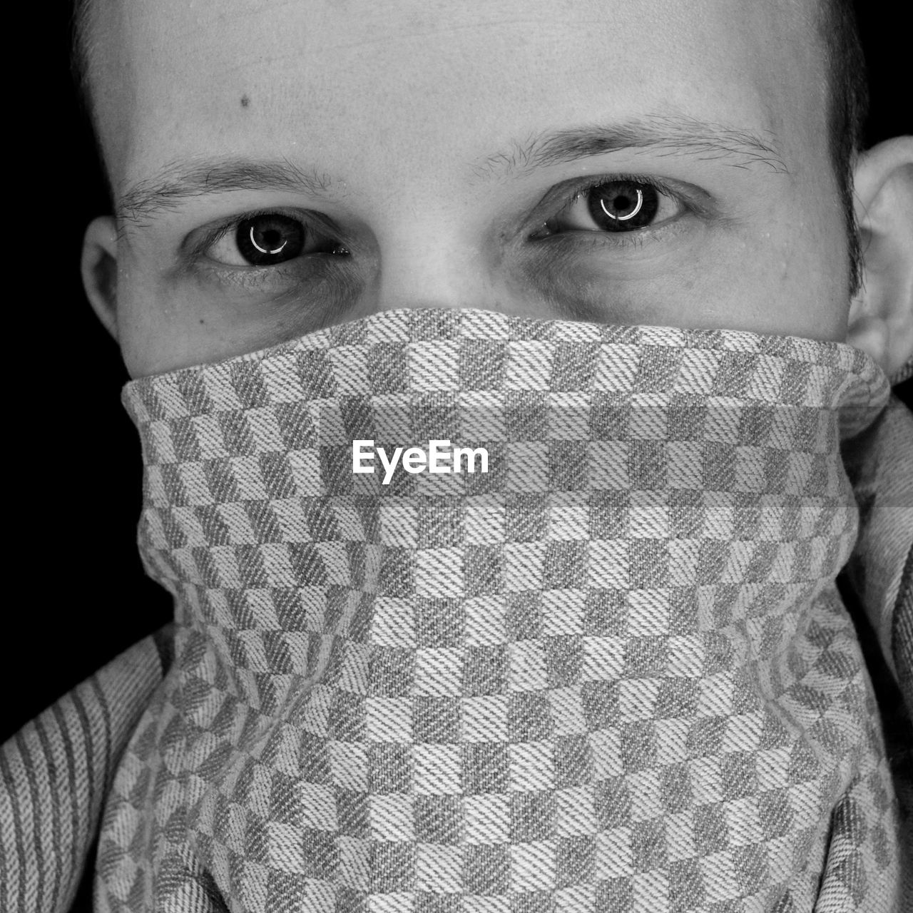 Close-up portrait of man with dish towel over face