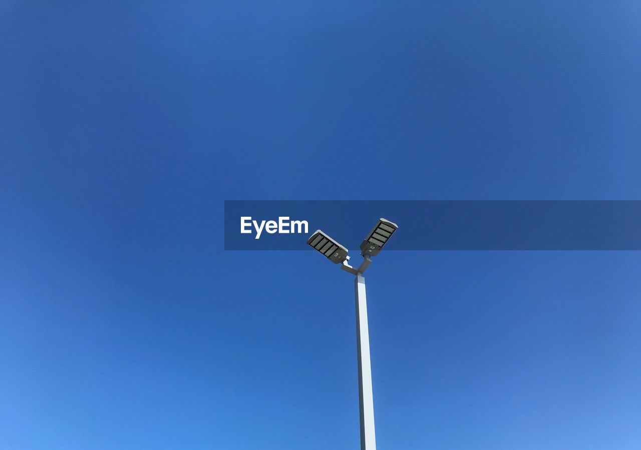 Low angle view of street light against blue sky