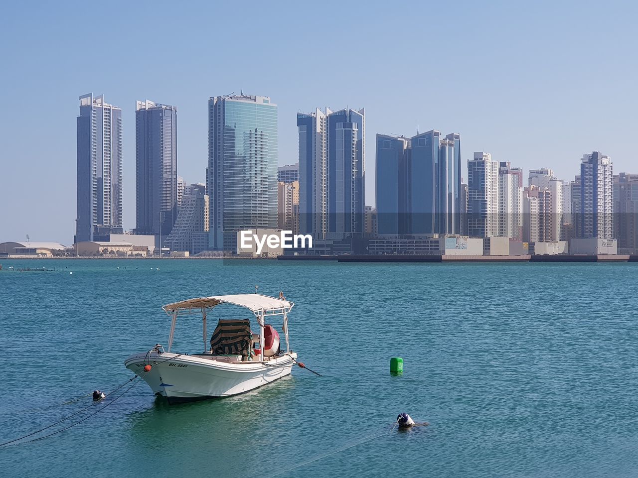 BOATS IN SEA AGAINST BUILDINGS IN CITY