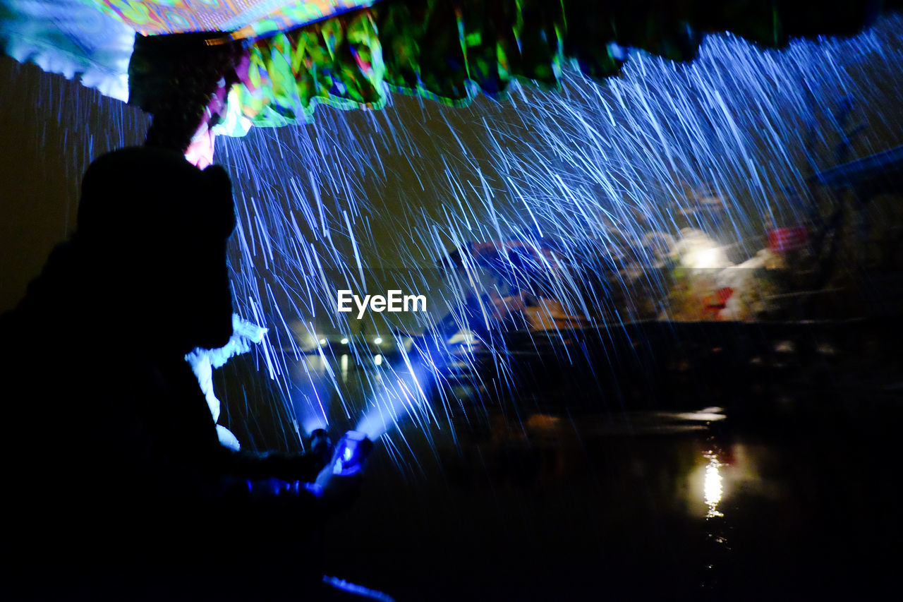 Man in illuminated water at night