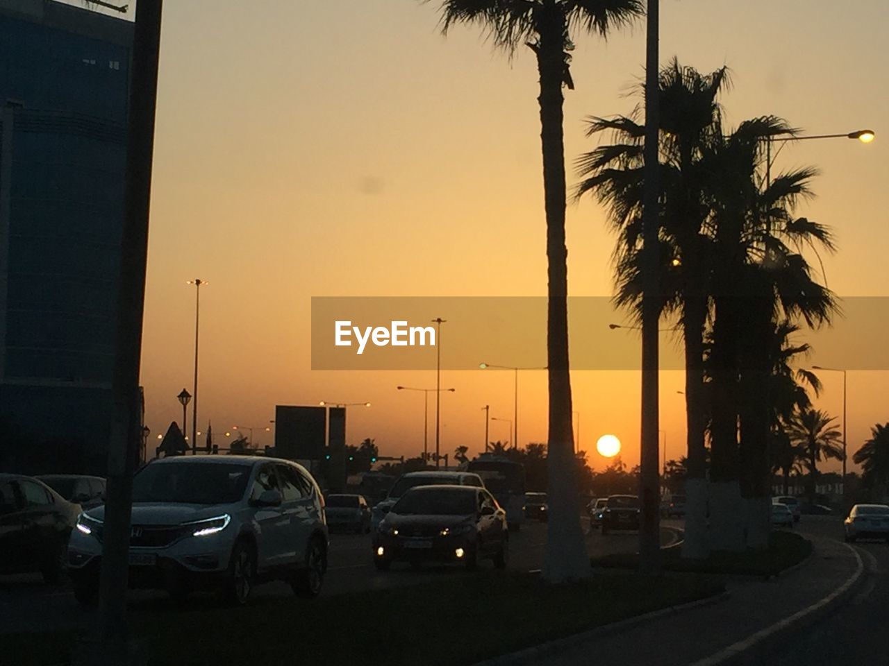 TRAFFIC ON ROAD AGAINST SKY DURING SUNSET