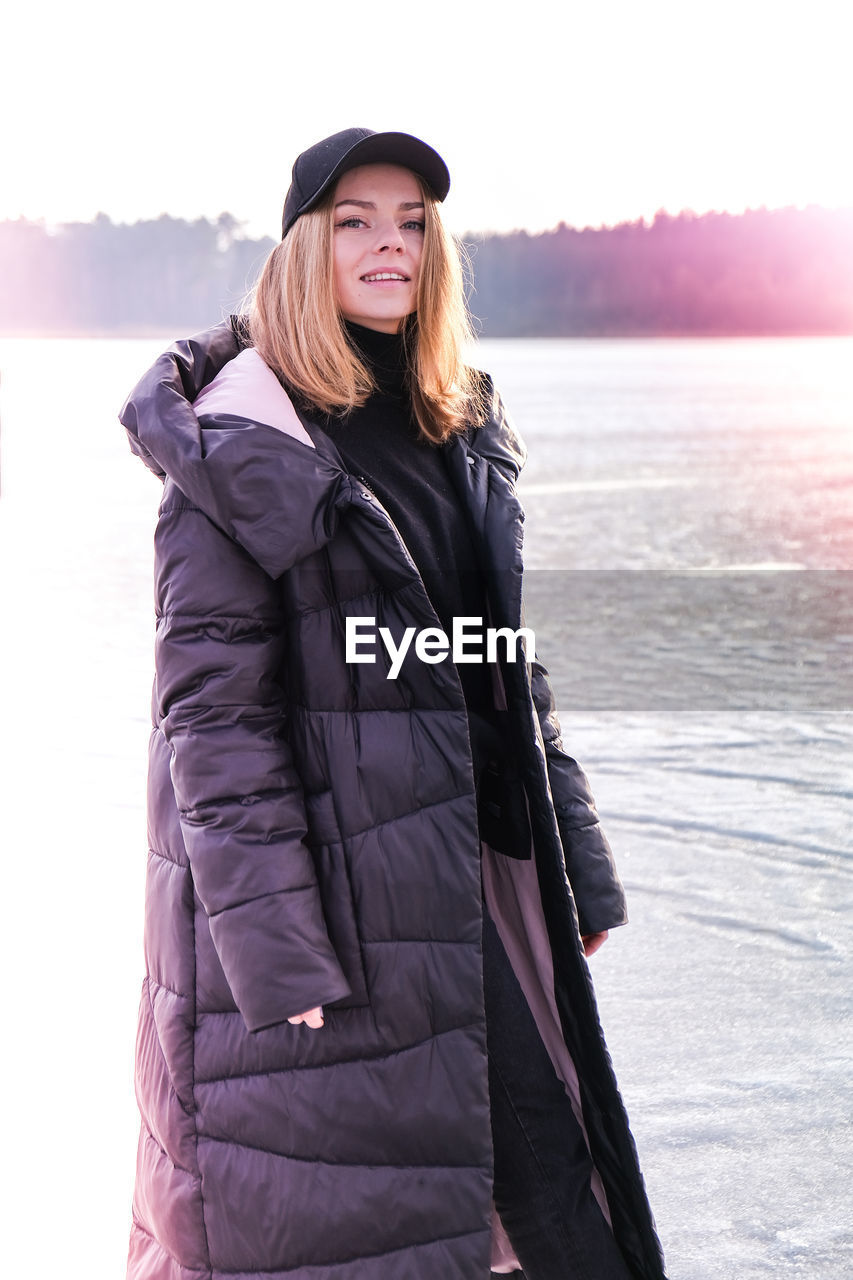 Young female smiling and looking at a camera in a snow landscape. happy hipster girl with hip hop 