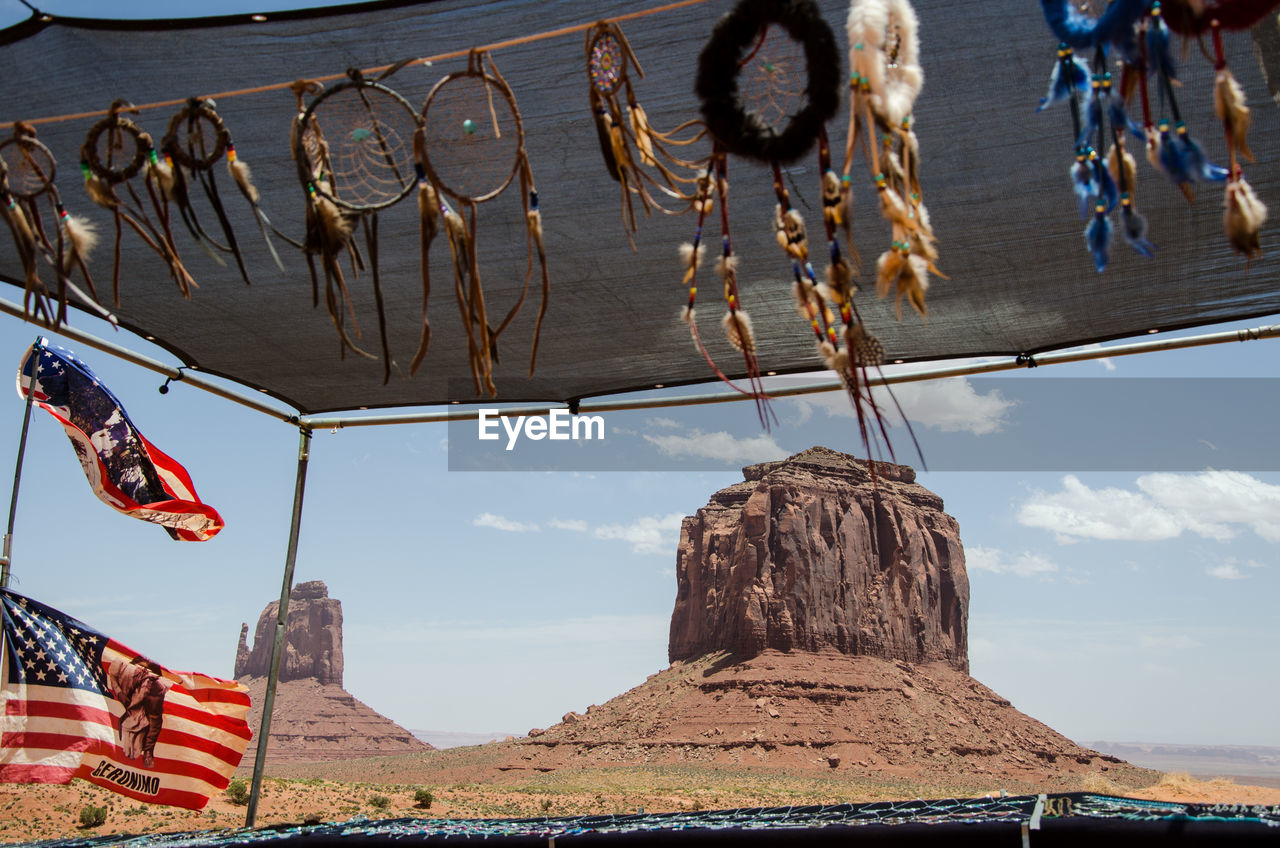 Monument valley rocks seen through a market stand selling indian flags and dreamcatchers