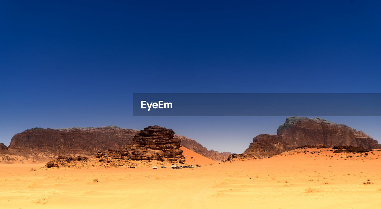 Scenic view of desert against clear blue sky