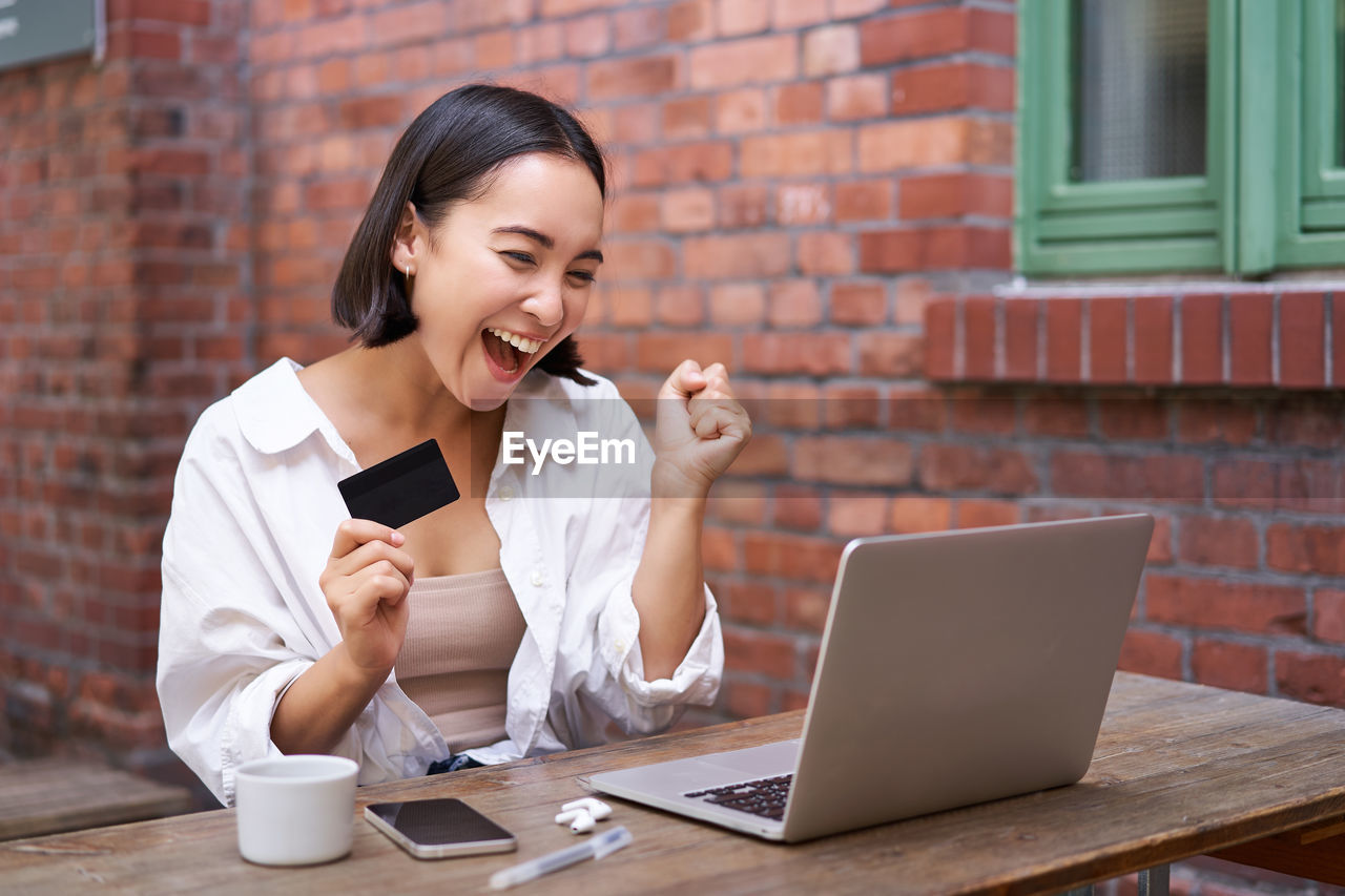 young man using laptop while sitting at table