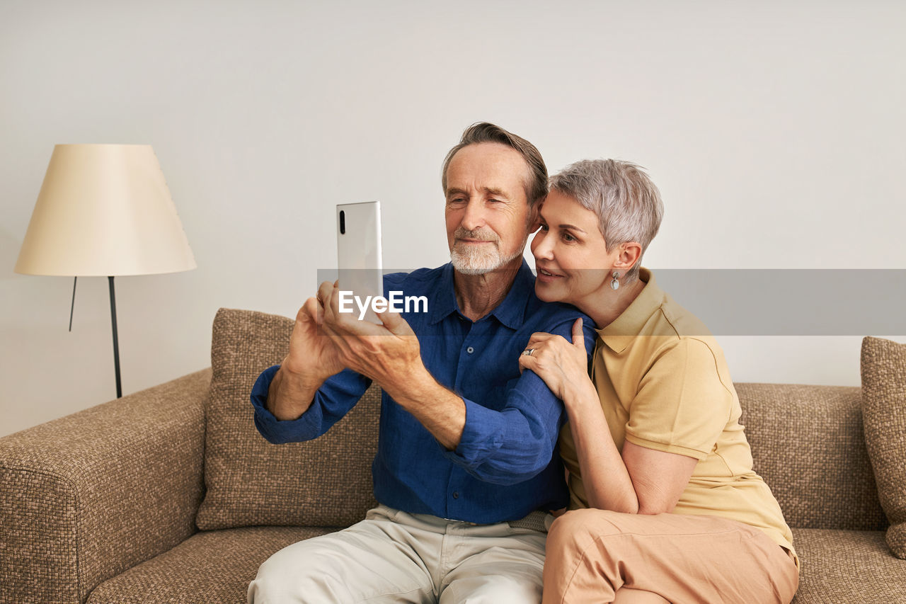 Senior couple talking on video call on smart phone at home