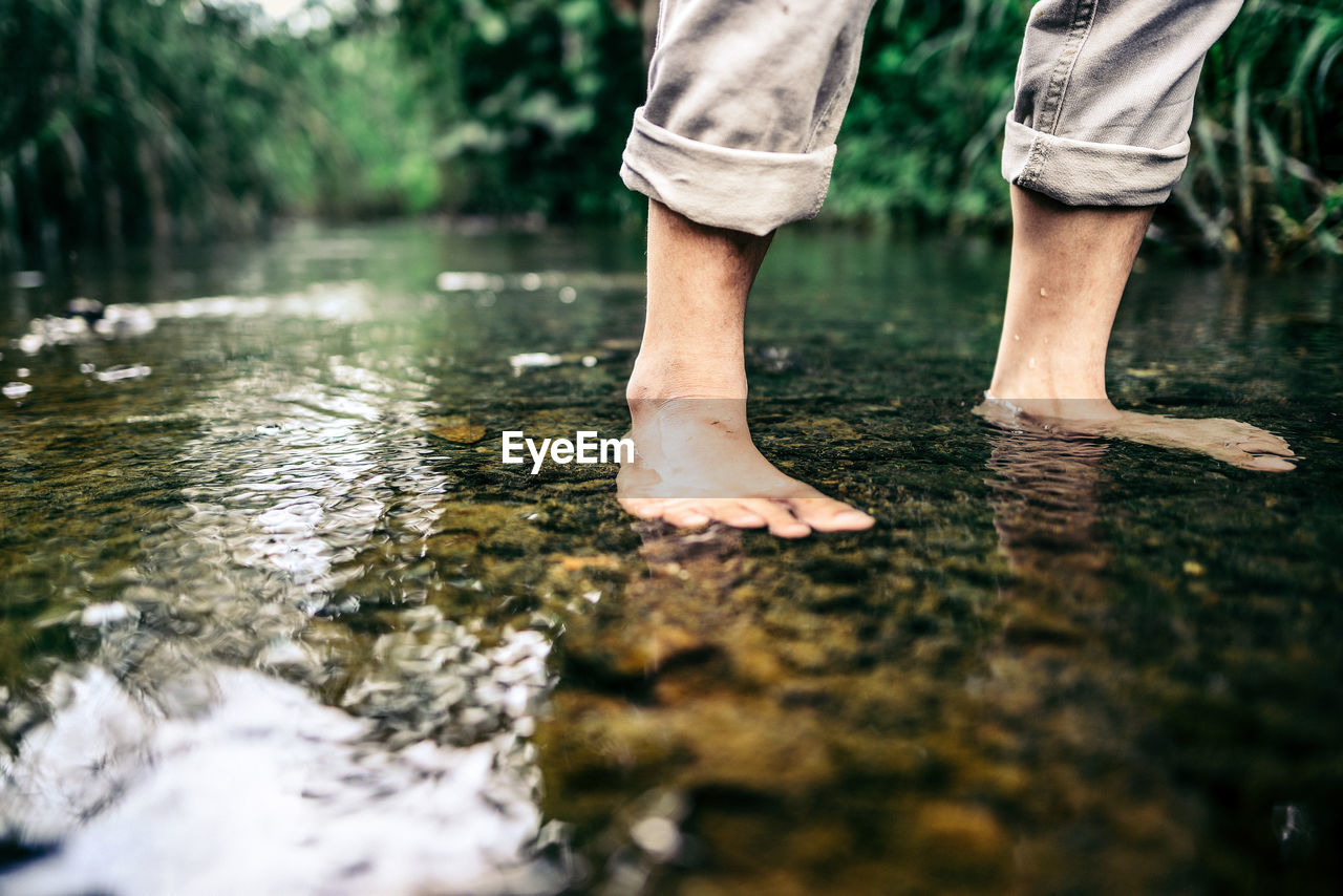 Low section of woman standing in water