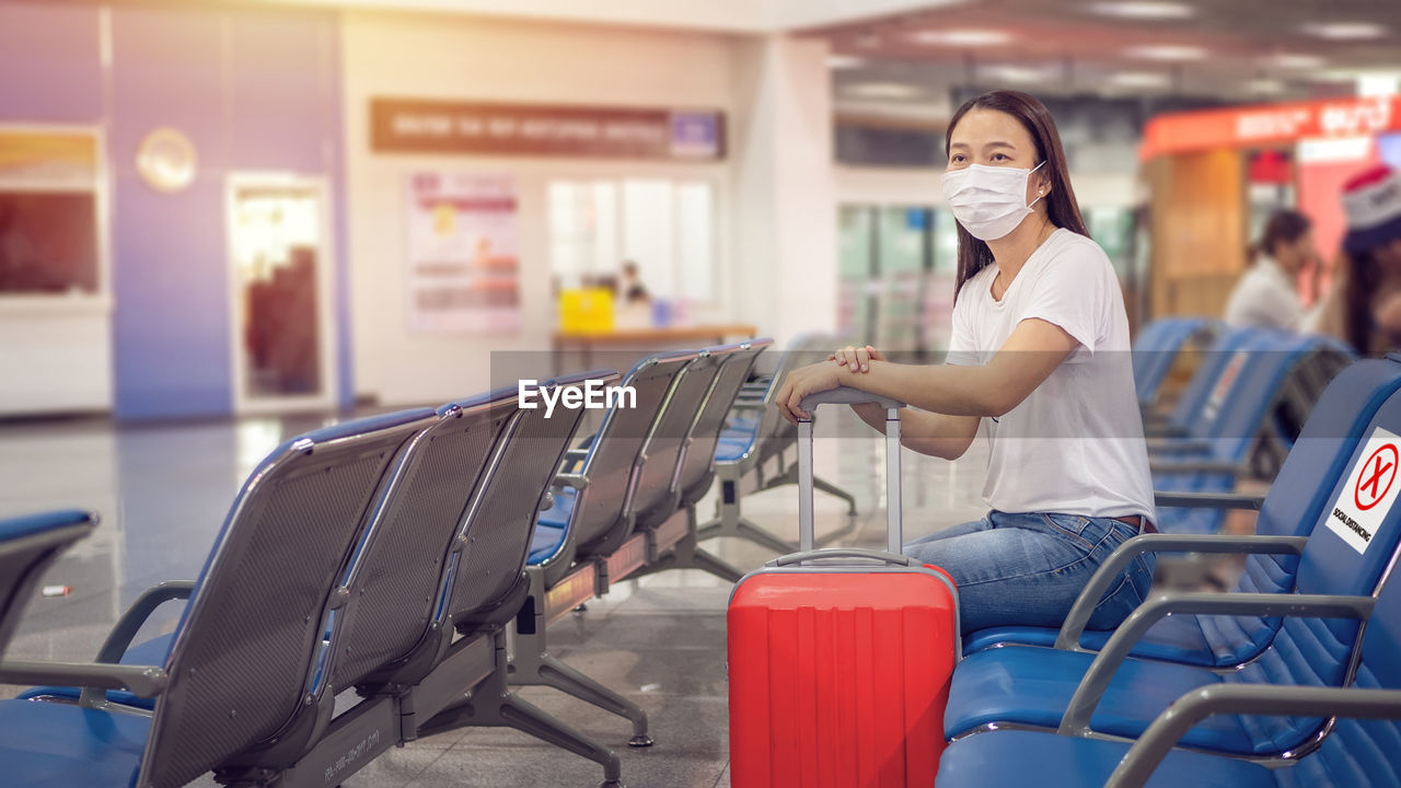 Woman sitting on seat at airport