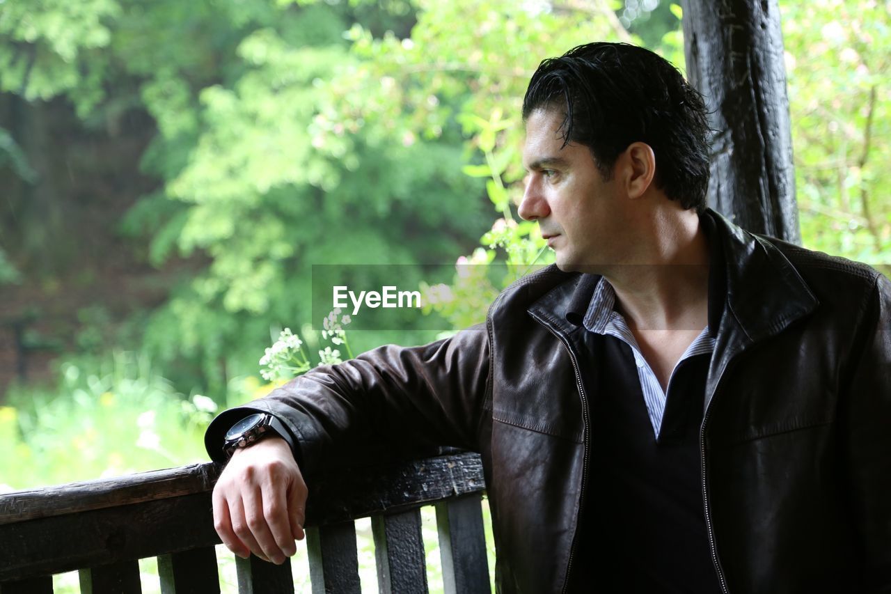 Man looking away while sitting on bench