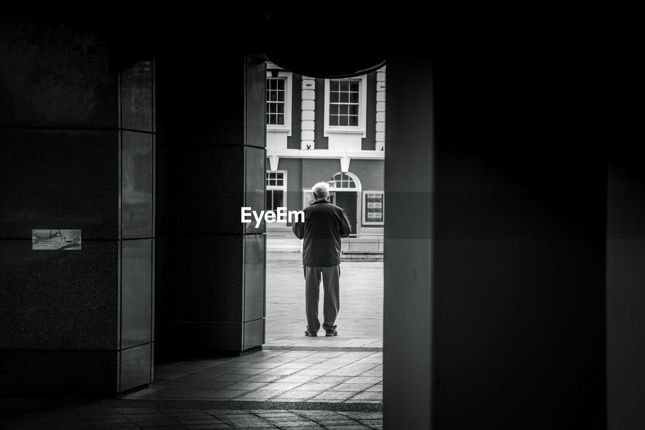 Full length rear view of man walking in corridor